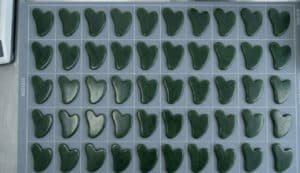 The jade Gua Sha tools arranged neatly on the desktop display a high degree of uniformity in both color and size.